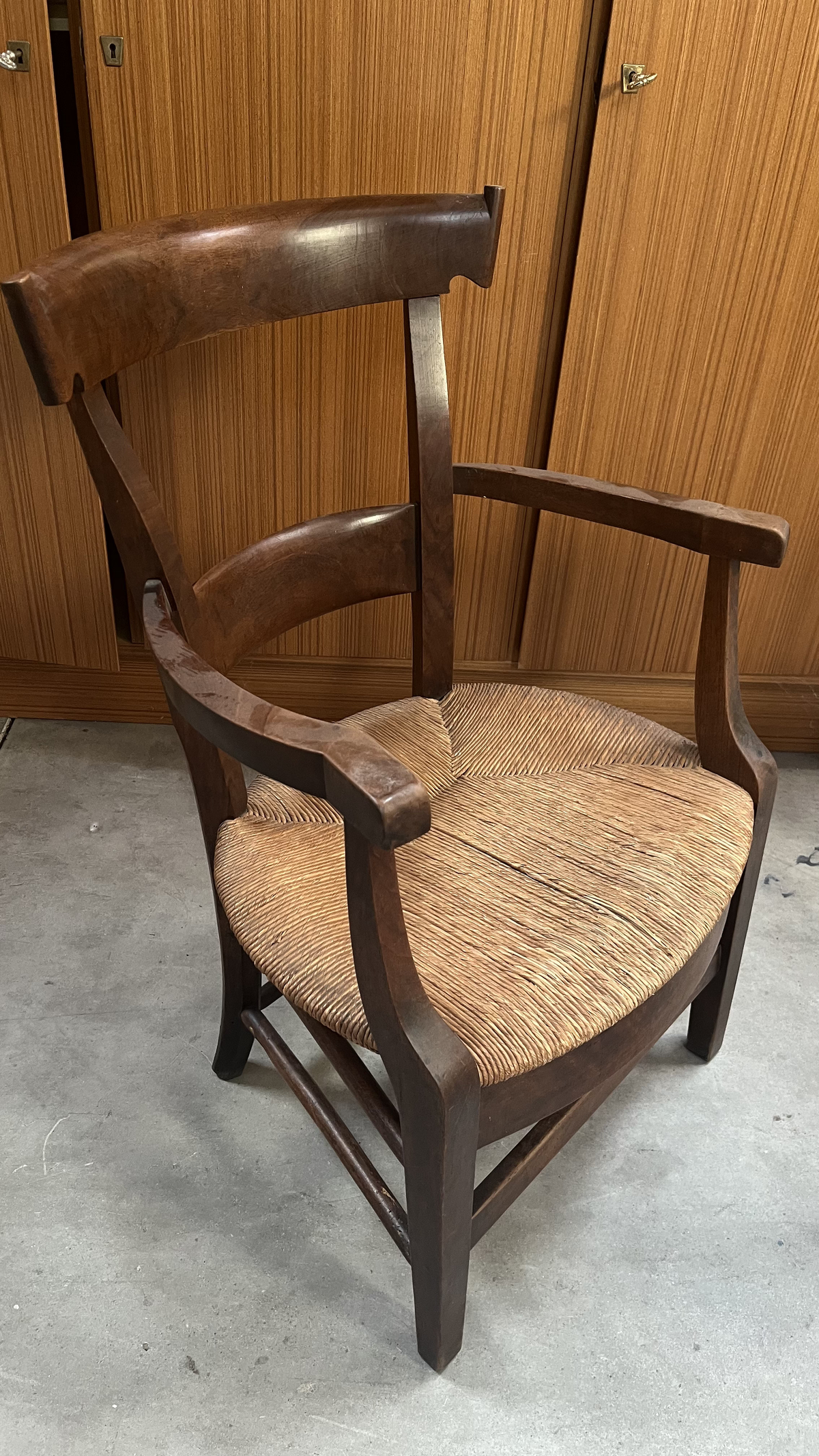 Fauteuil rustique en bois foncé à assise paillée