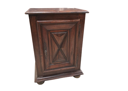 Petit meuble en bois foncé à porte moulurée