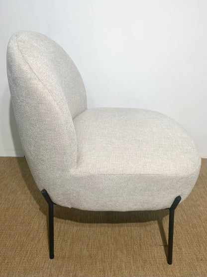 Fauteuil enveloppant en tissu beige sur pieds en métal noir