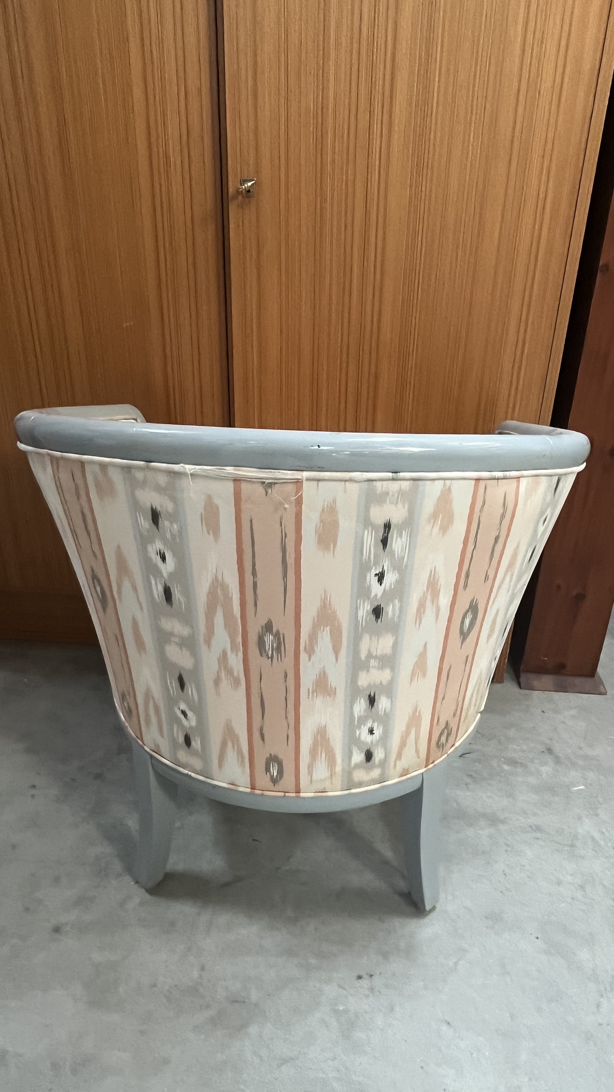 Fauteuil tonneau en bois gris et tissu à motifs