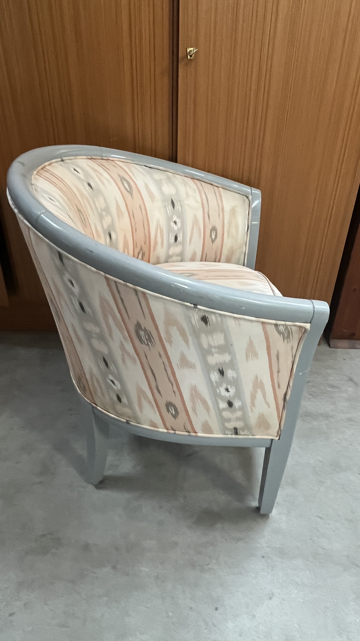 Fauteuil tonneau en bois gris et tissu à motifs