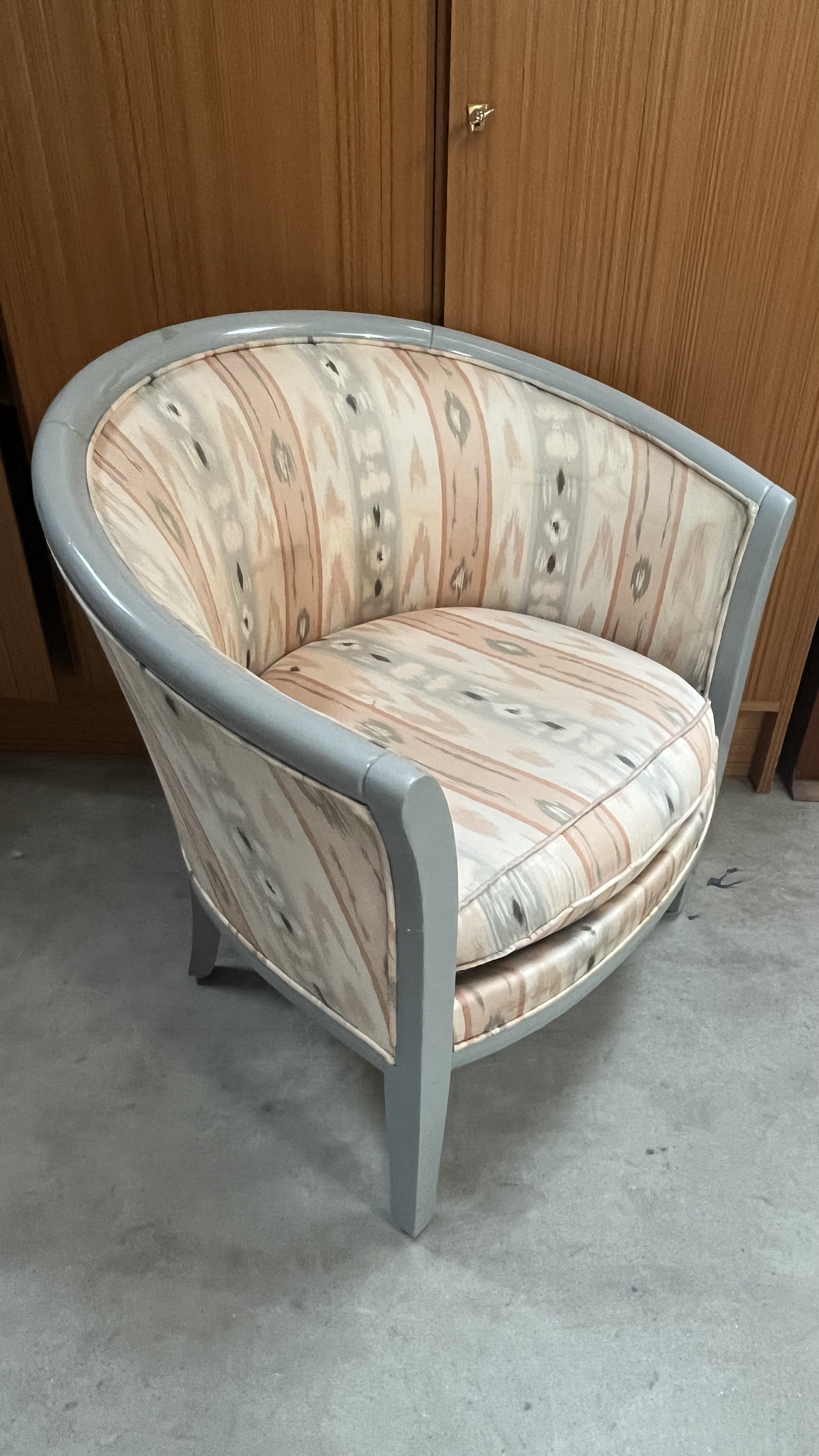 Fauteuil tonneau en bois gris et tissu à motifs