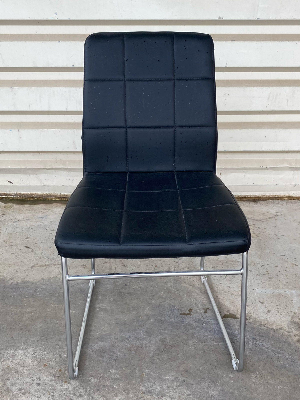 Chaise matelassée en cuir noir sur piètement chromé