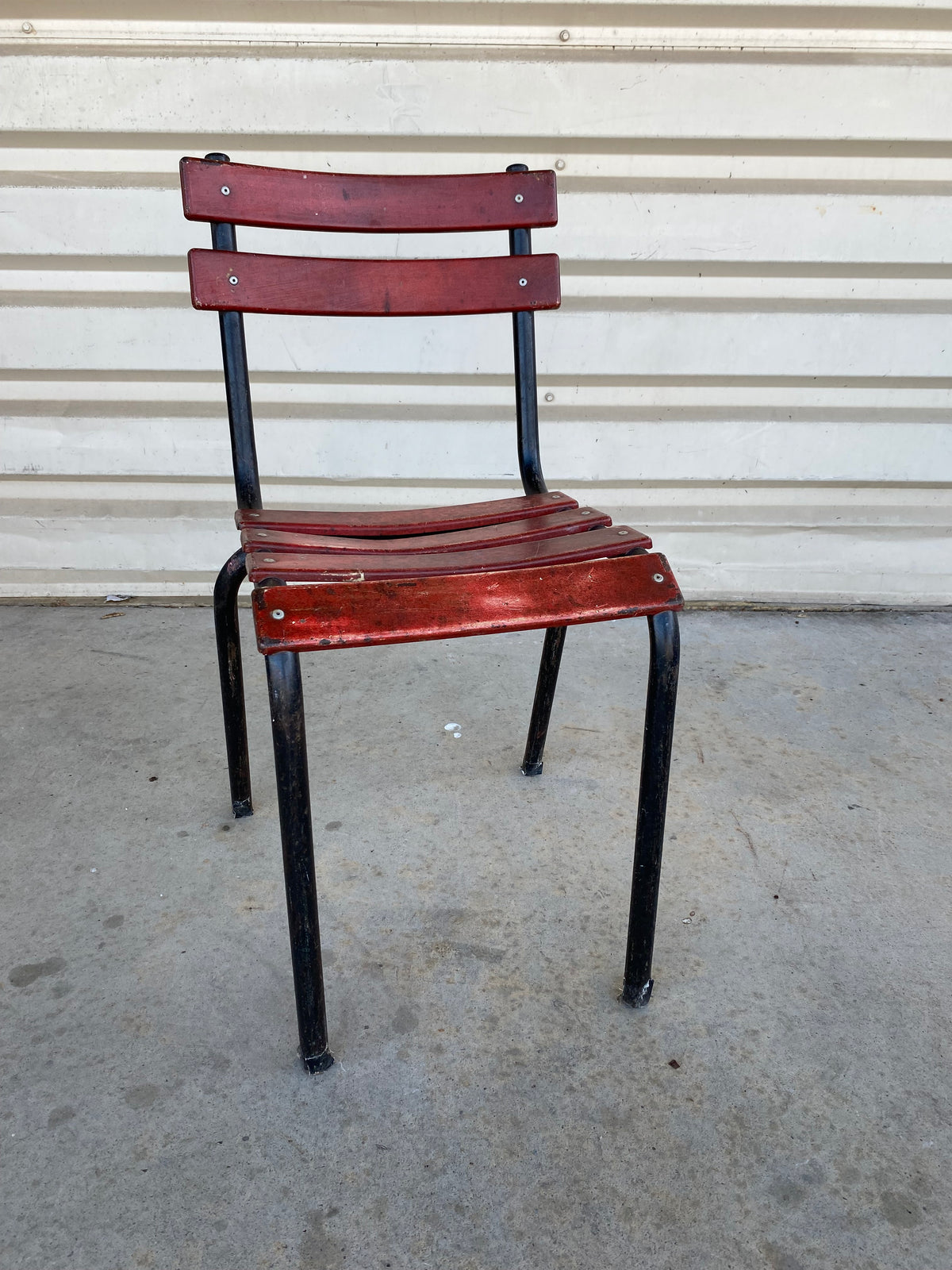 Chaise à lattes de bois rouge et métal noir