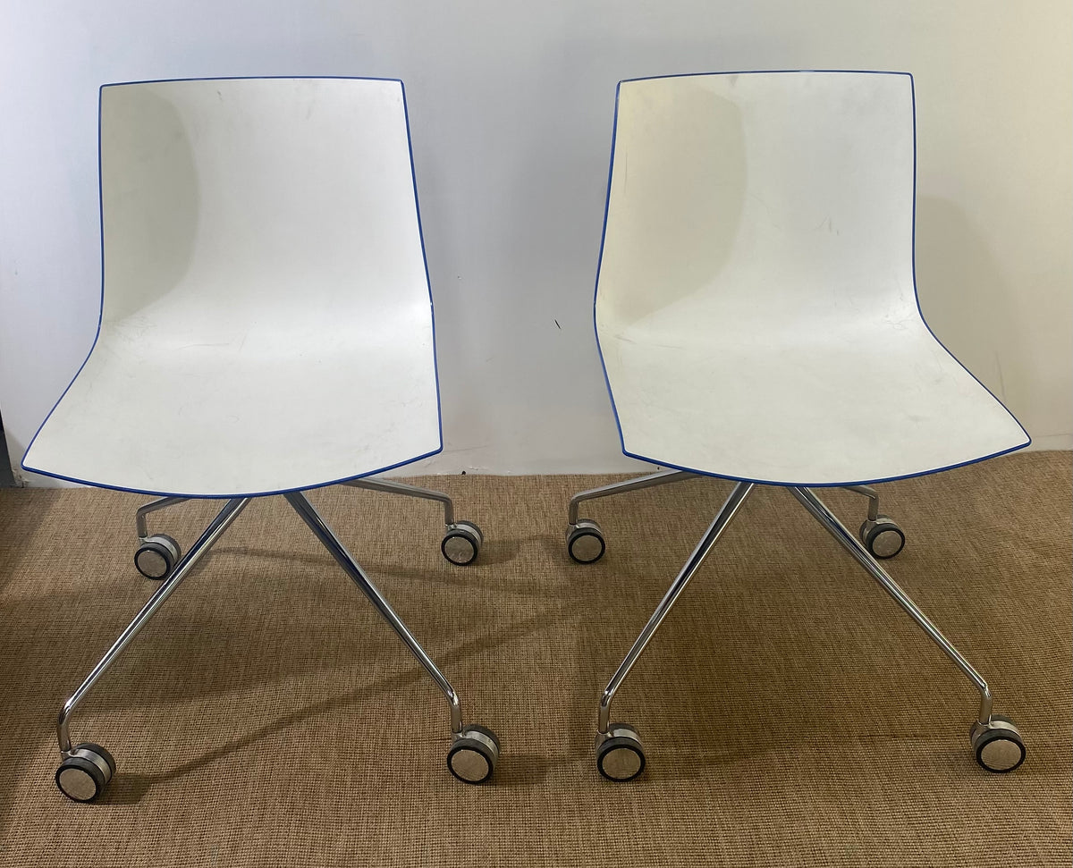 Paire de chaises coque en plastique blanc à roulettes