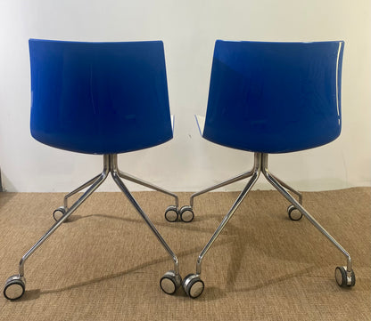 Paire de chaises coque en plastique blanc à roulettes