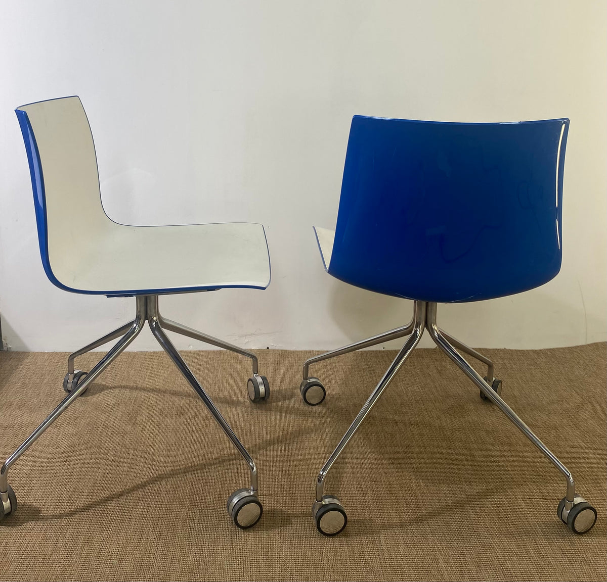Paire de chaises coque en plastique blanc à roulettes