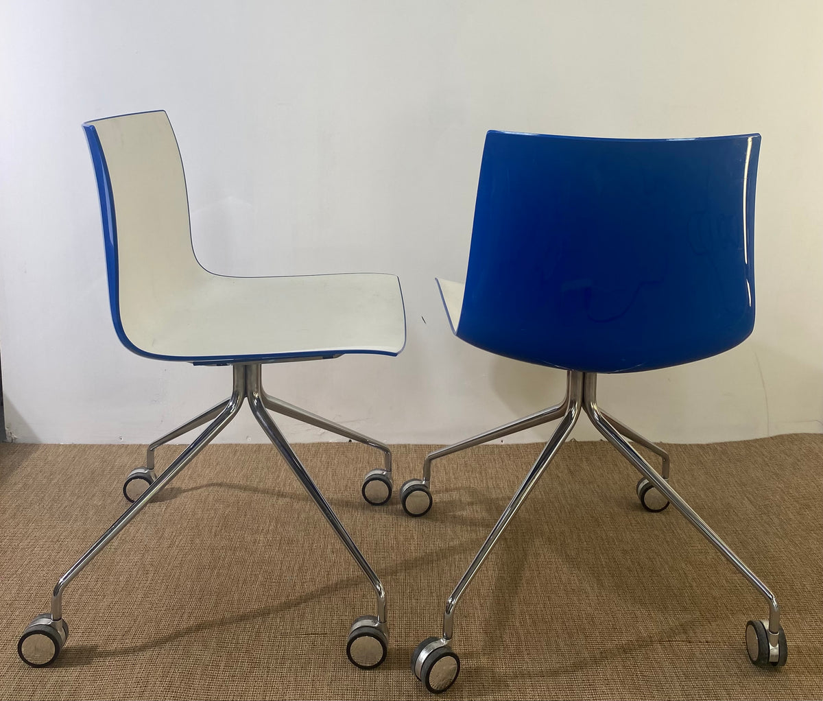 Paire de chaises coque en plastique blanc à roulettes