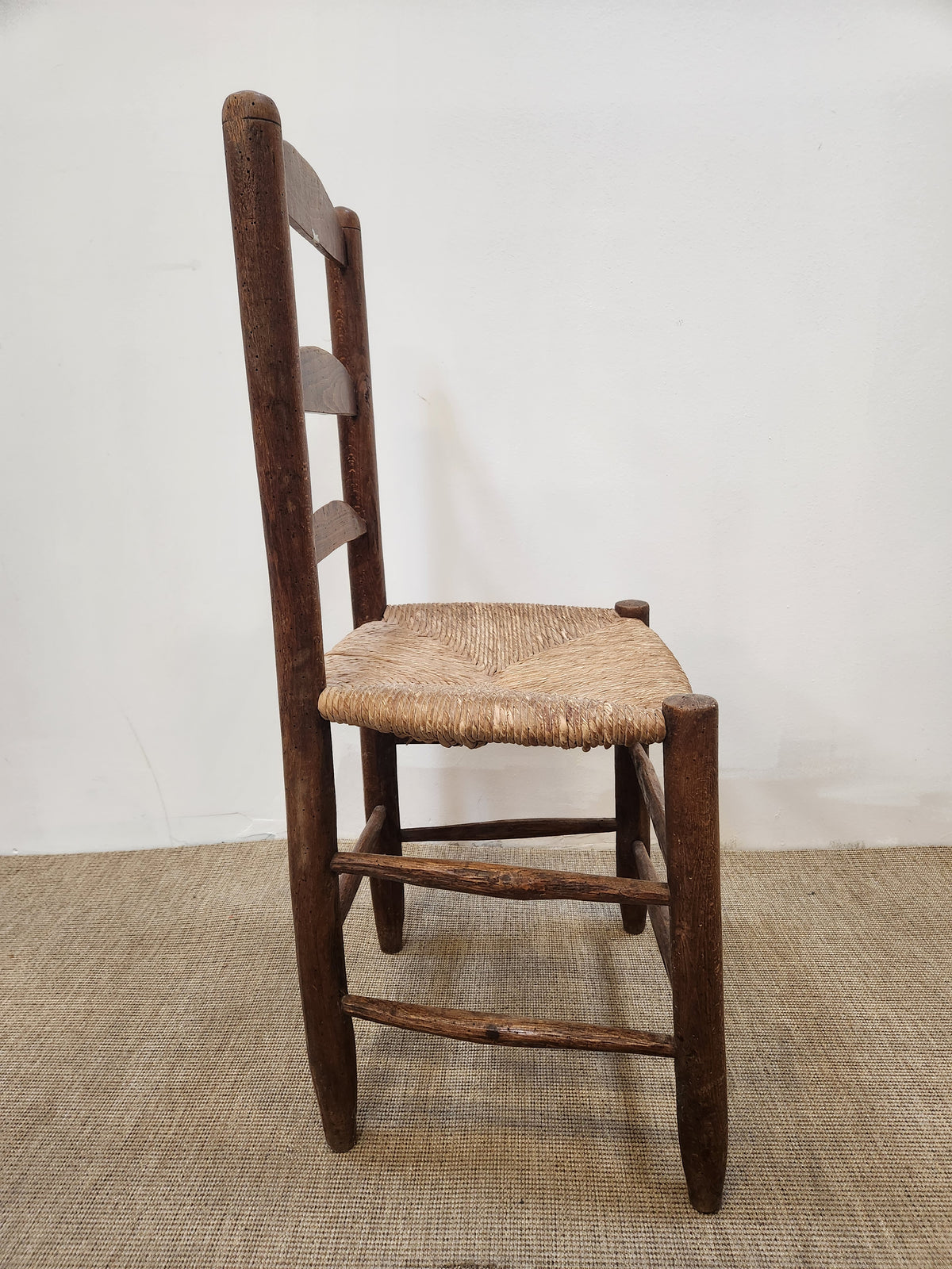 Chaise en bois foncé à barrettes et assise paillée
