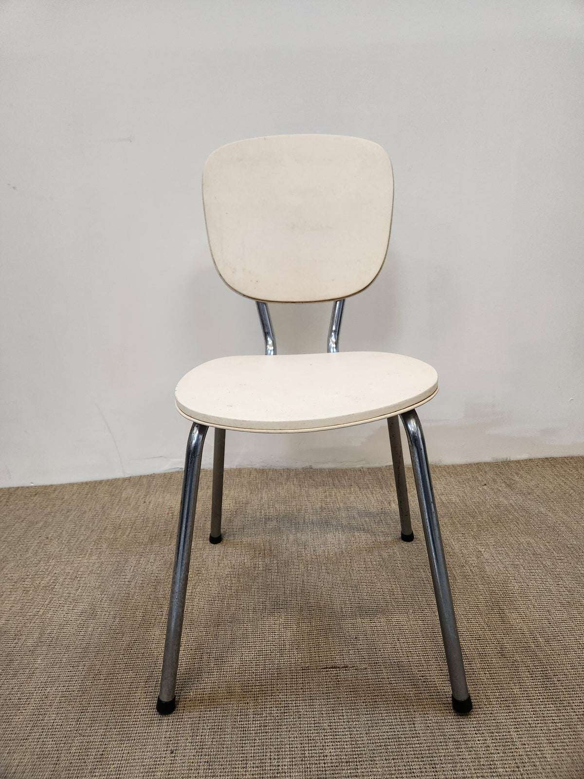 Chaise vintage blanche rembourrée sur pieds chromés