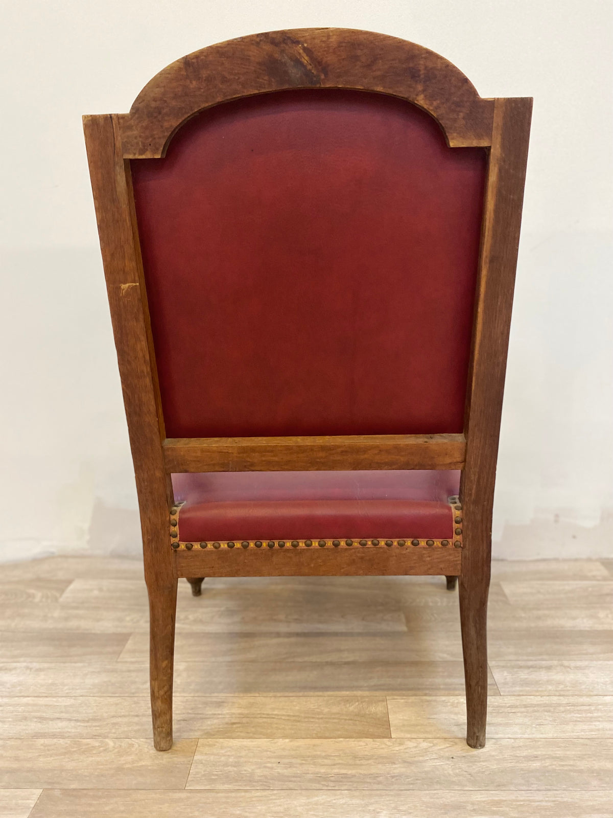 Fauteuil en bois sculpté et cuir bordeaux clouté