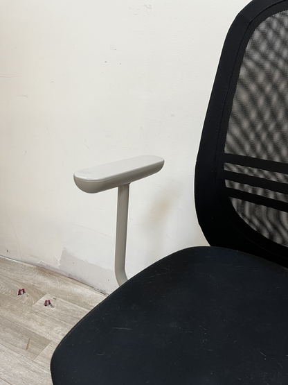 Chaise de bureau noire à dossier en résille et accoudoirs clairs