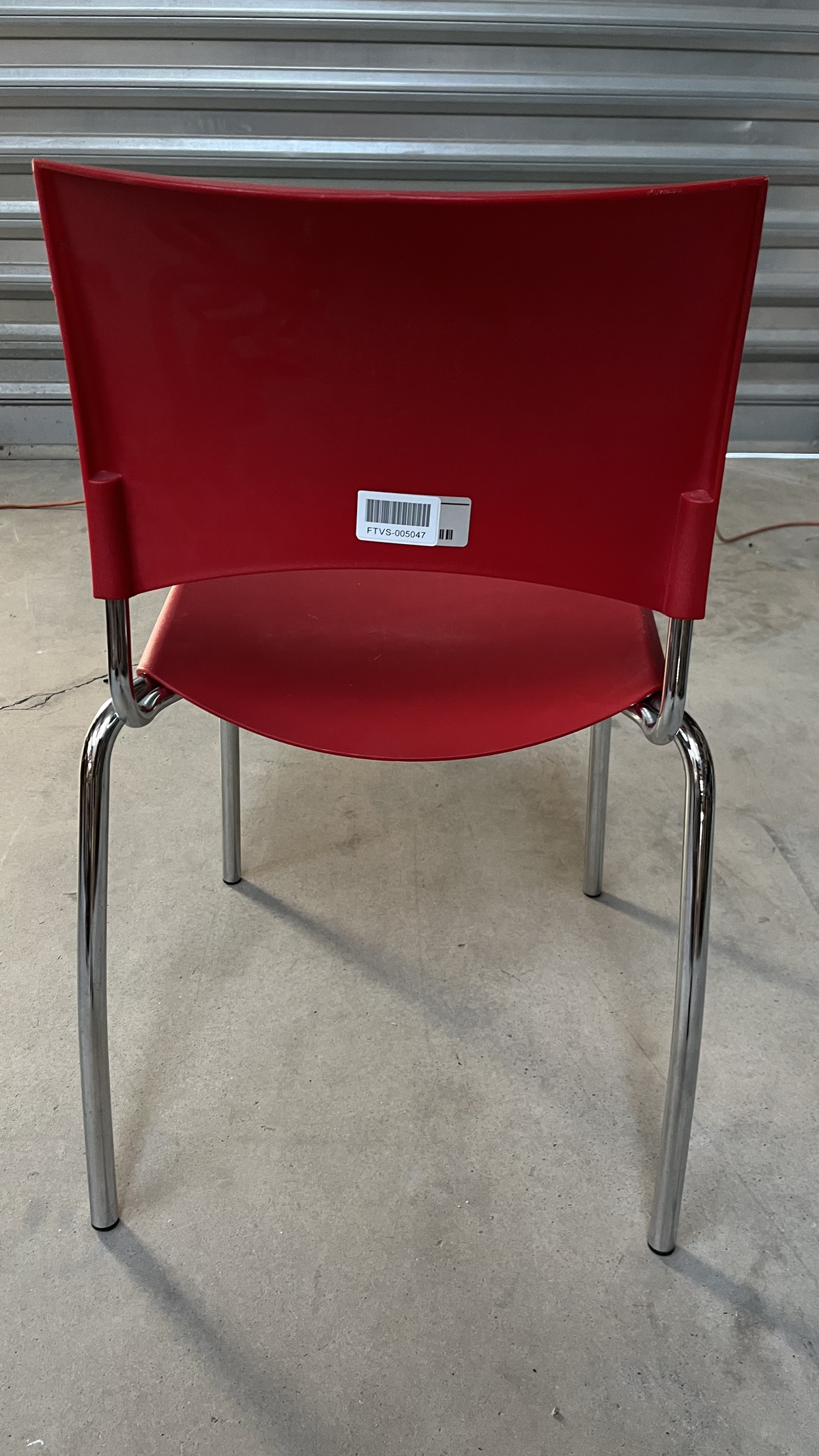 Chaise en plastique rouge sur pieds en métal gris