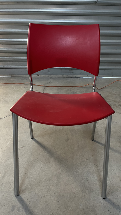 Chaise en plastique rouge sur pieds en métal gris