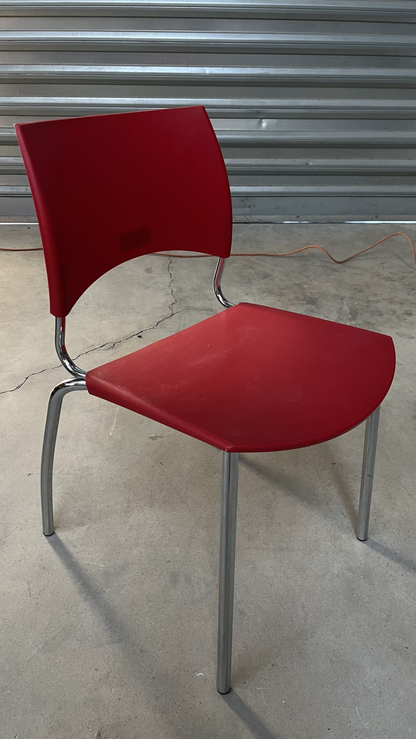 Chaise en plastique rouge sur pieds en métal gris