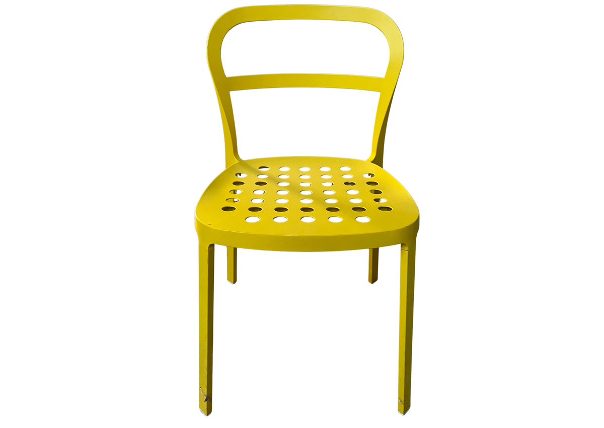 Chaise en métal jaune à assise perforée