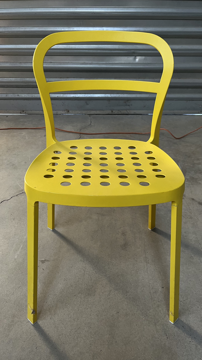 Chaise en métal jaune à assise perforée