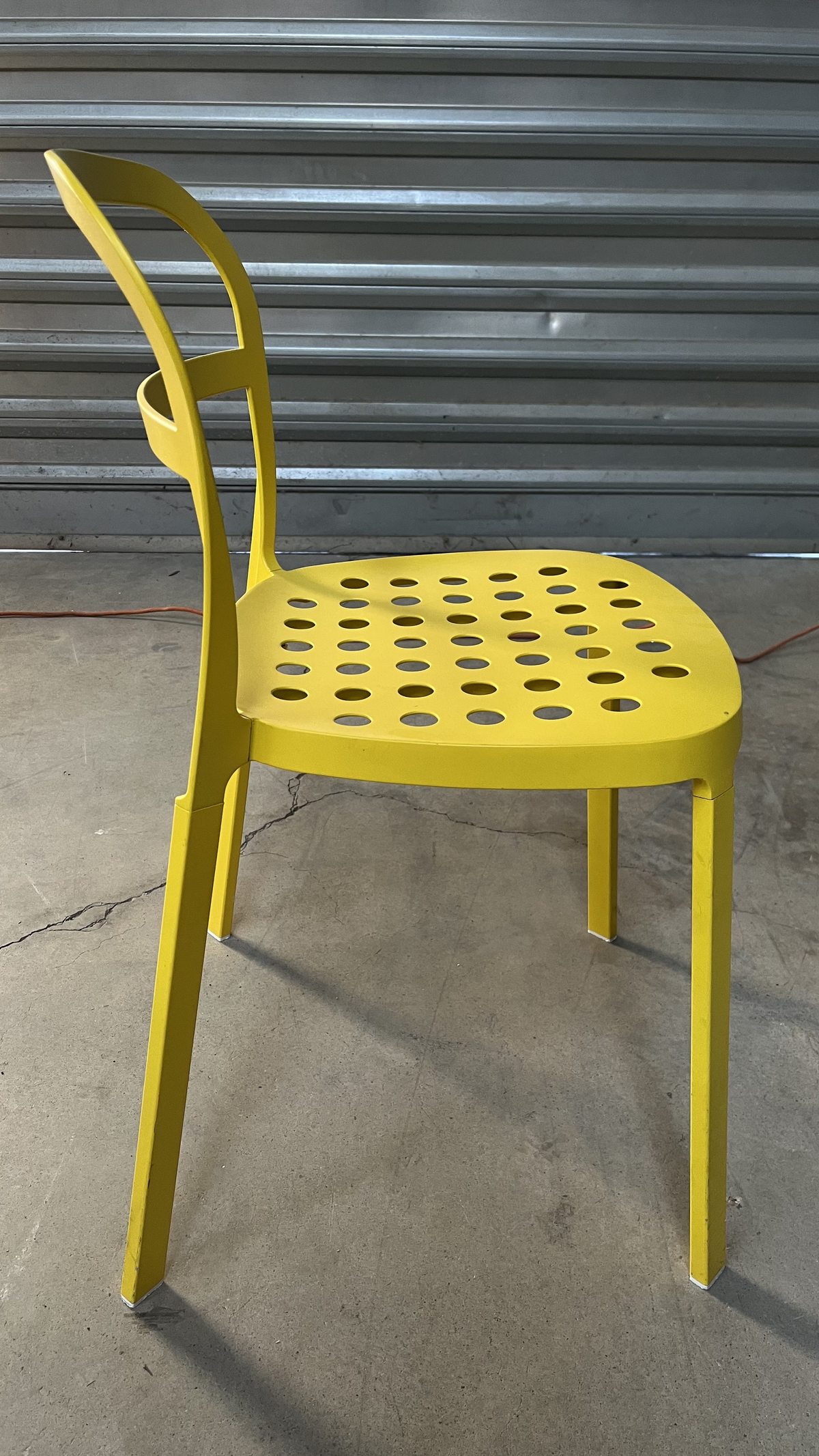 Chaise en métal jaune à assise perforée