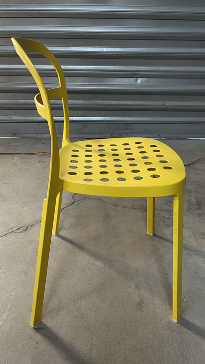 Chaise en métal jaune à assise perforée