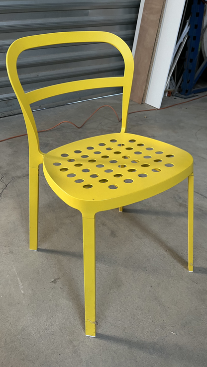 Chaise en métal jaune à assise perforée