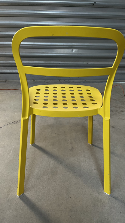 Chaise en métal jaune à assise perforée