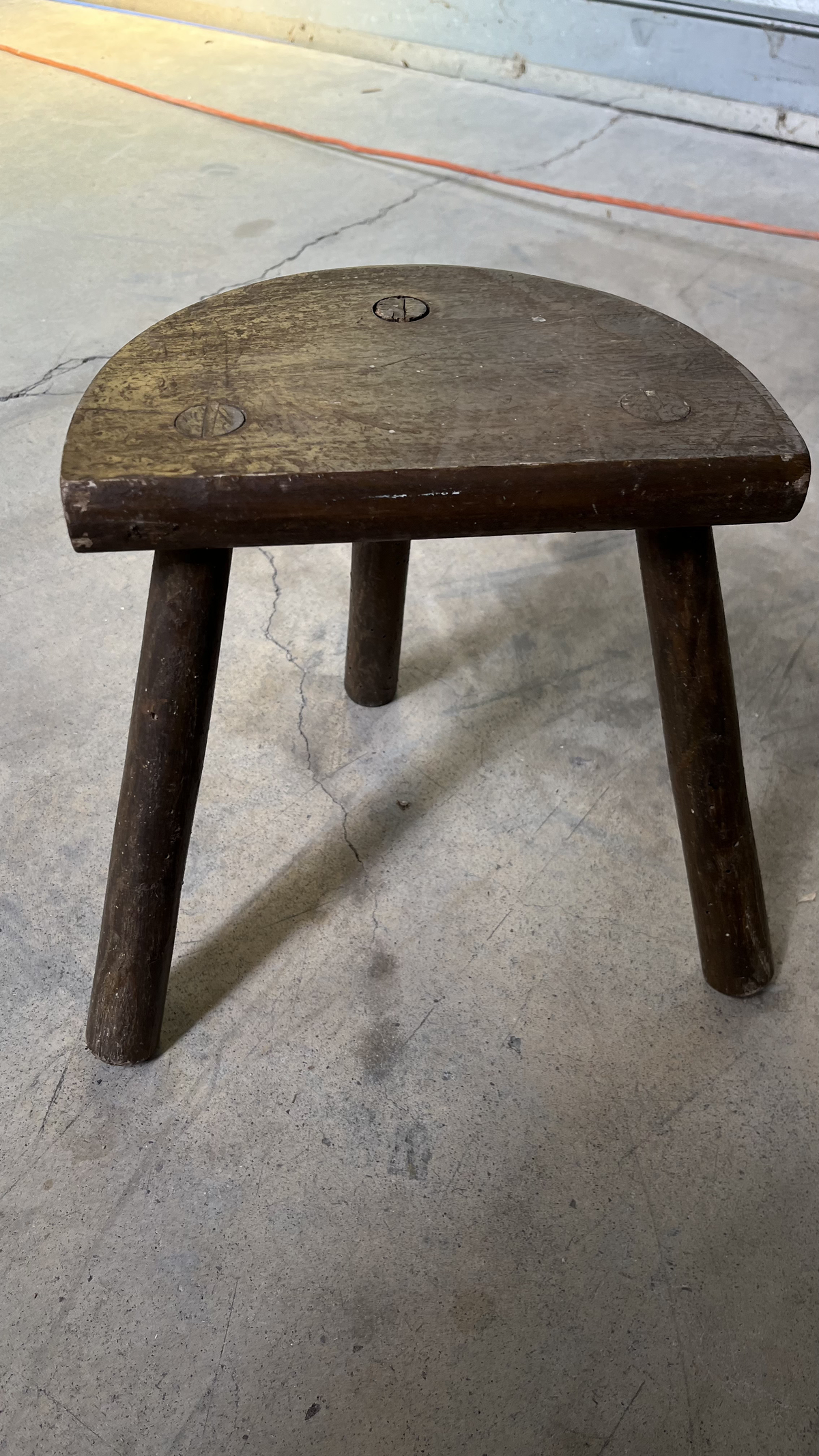 Tabouret tripode en bois patiné à assise demi-lune