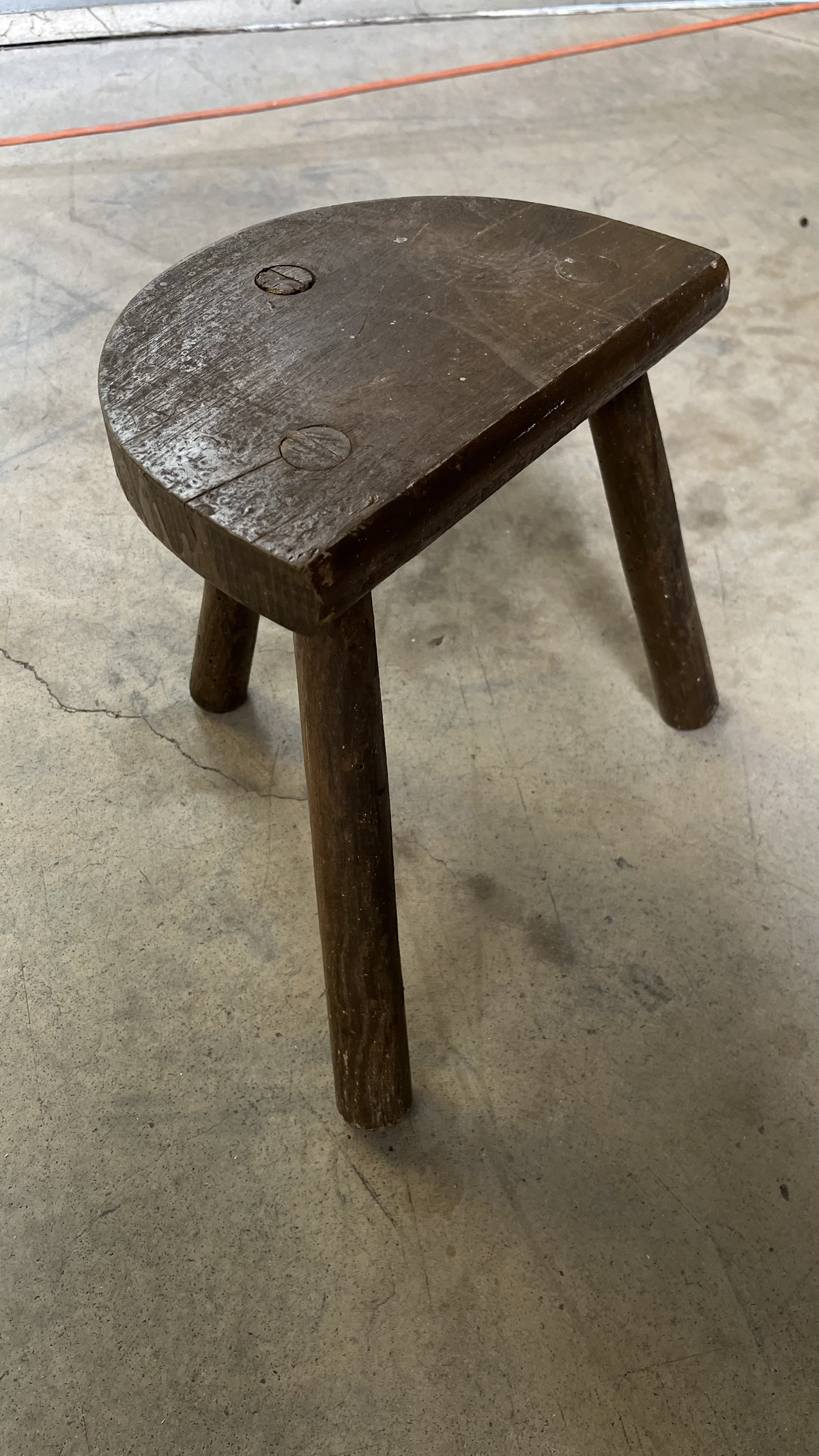 Tabouret tripode en bois patiné à assise demi-lune