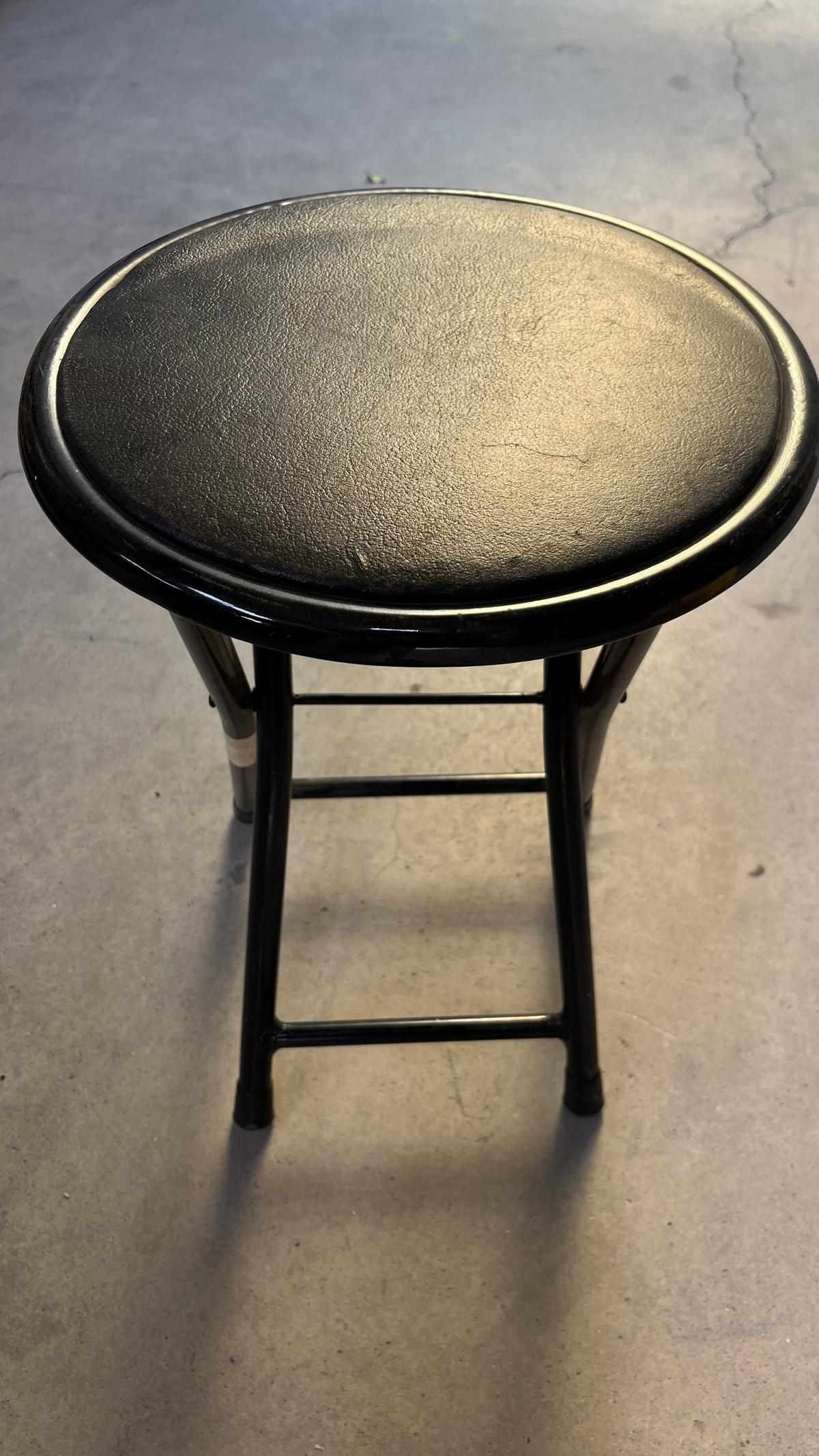 Tabouret à assise ronde noire sur pieds en métal