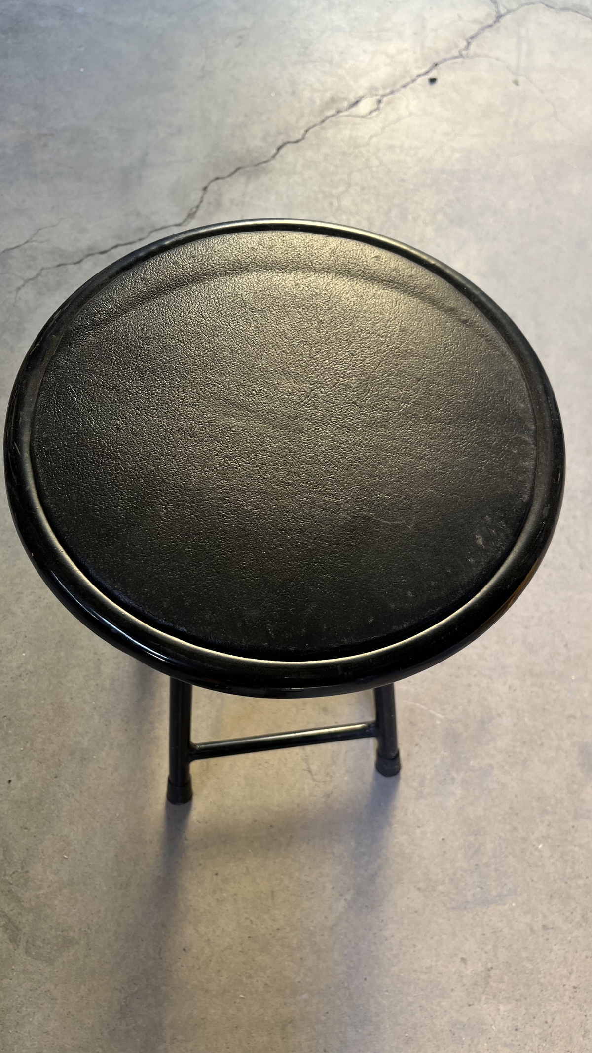 Tabouret à assise ronde noire sur pieds en métal