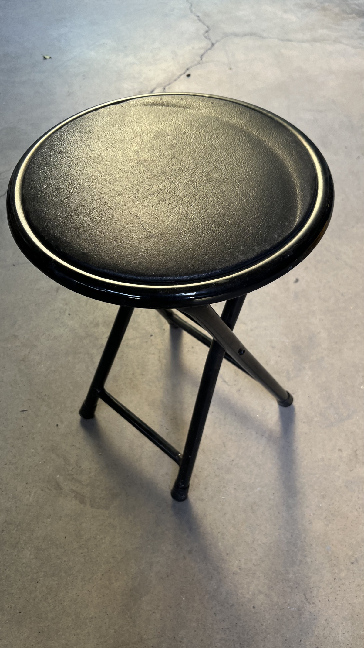 Tabouret à assise ronde noire sur pieds en métal
