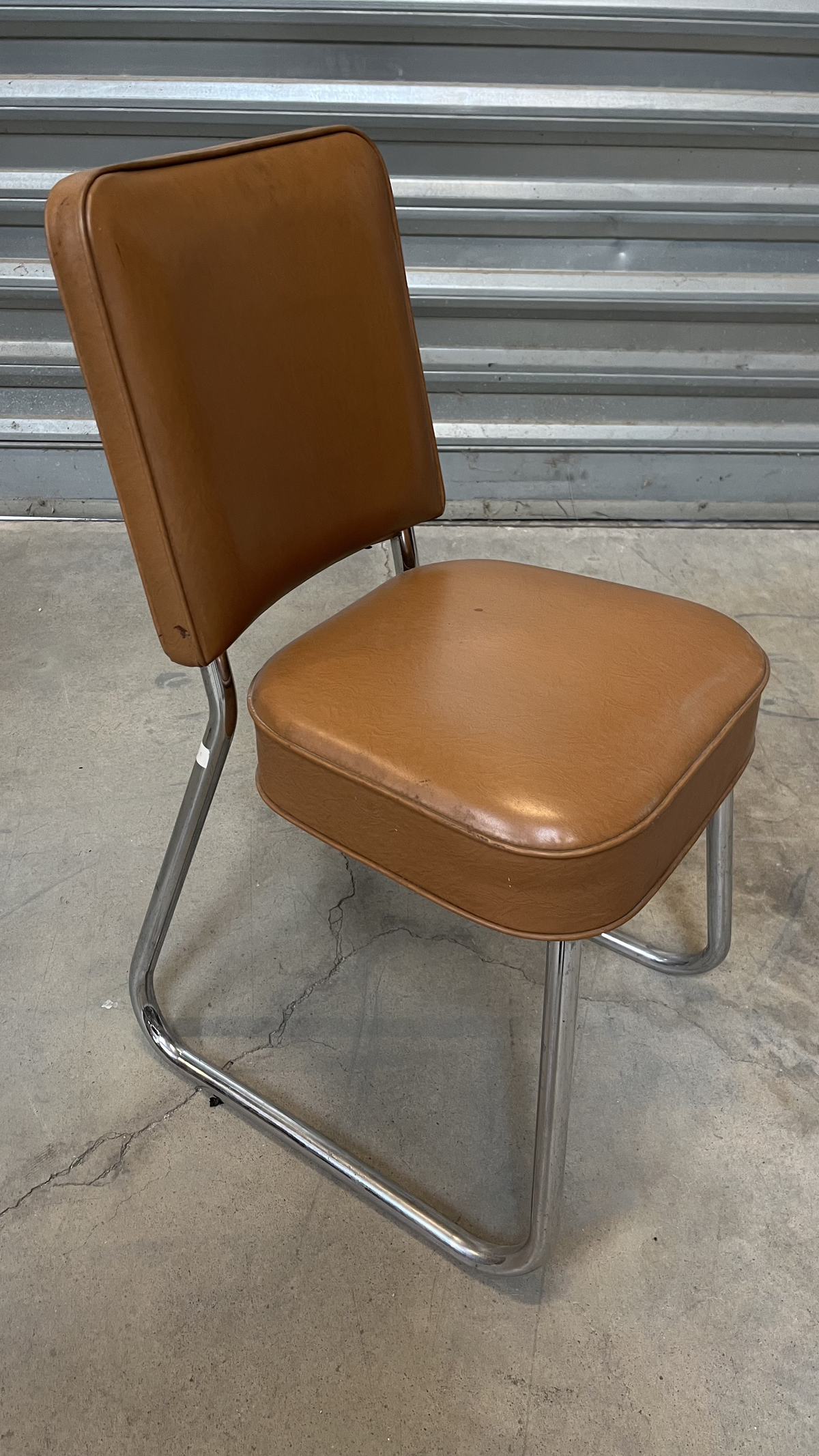 Chaise en cuir marron sur piètement luge chromé