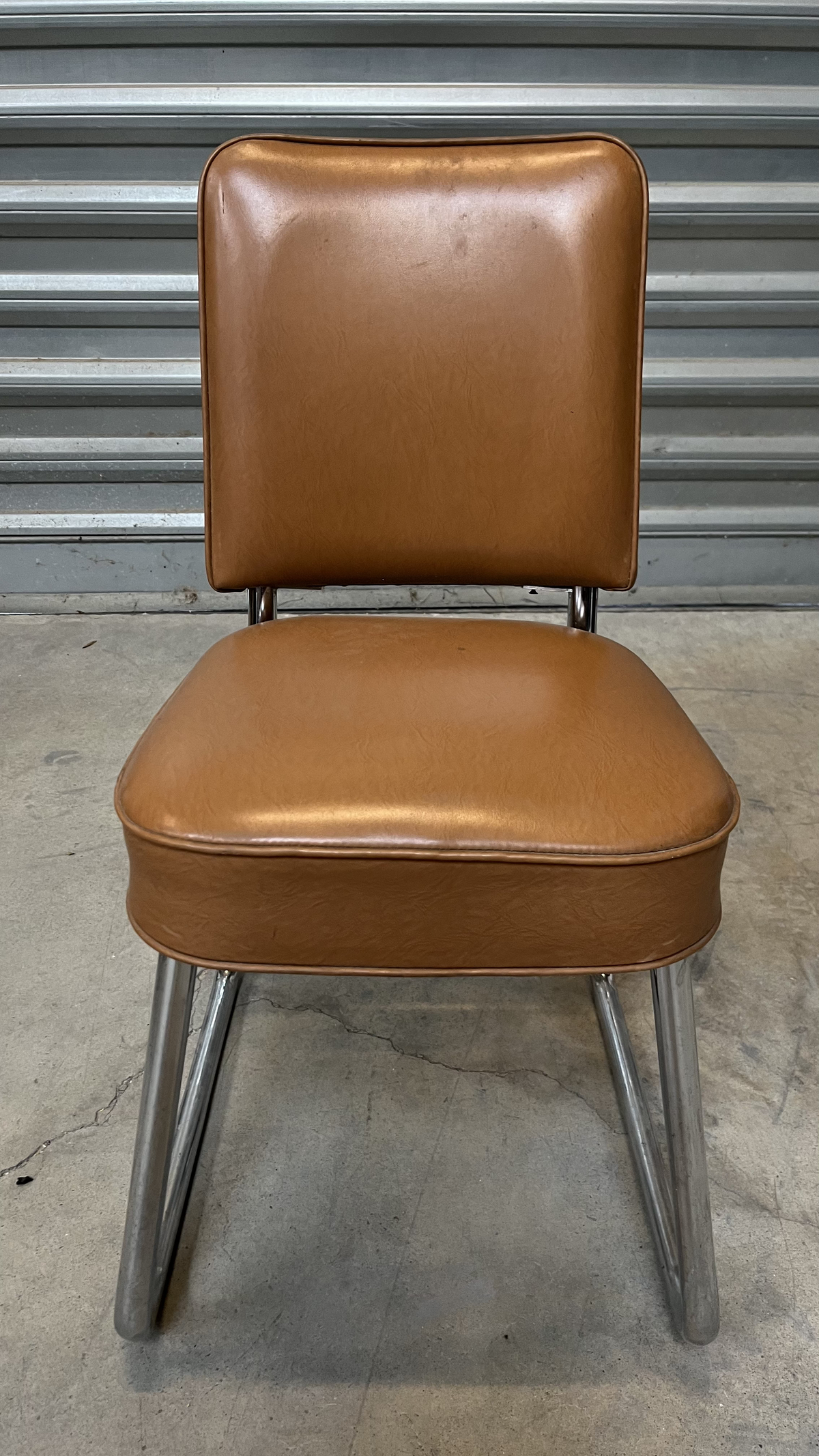 Chaise en cuir marron sur piètement luge chromé