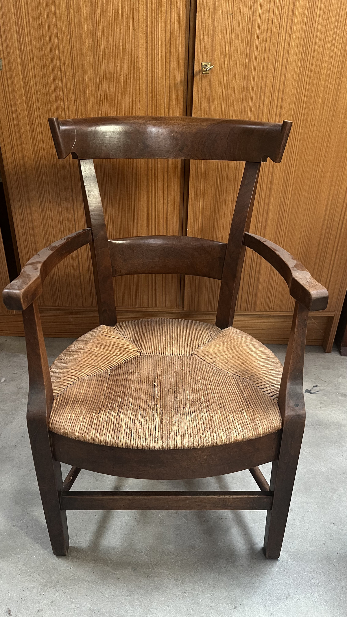 Fauteuil rustique en bois foncé à assise paillée