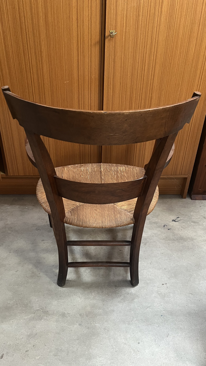 Fauteuil rustique en bois foncé à assise paillée