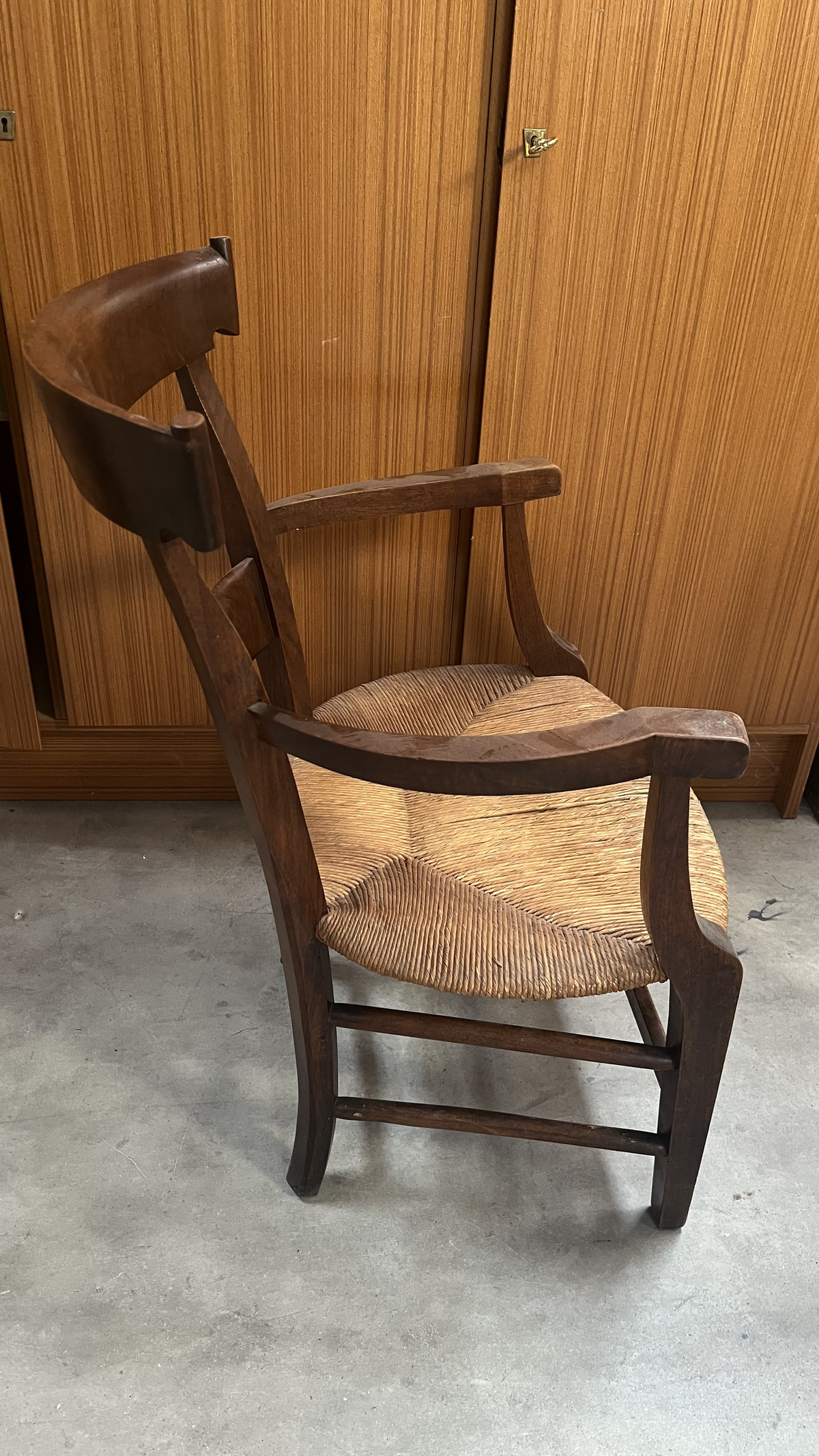 Fauteuil rustique en bois foncé à assise paillée